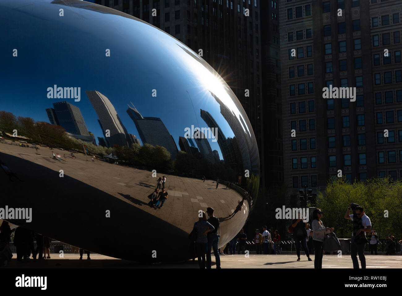 Il fagiolo in Millennium Park che riflette un cielo blu, gli edifici e le persone - Chicago, IL Foto Stock