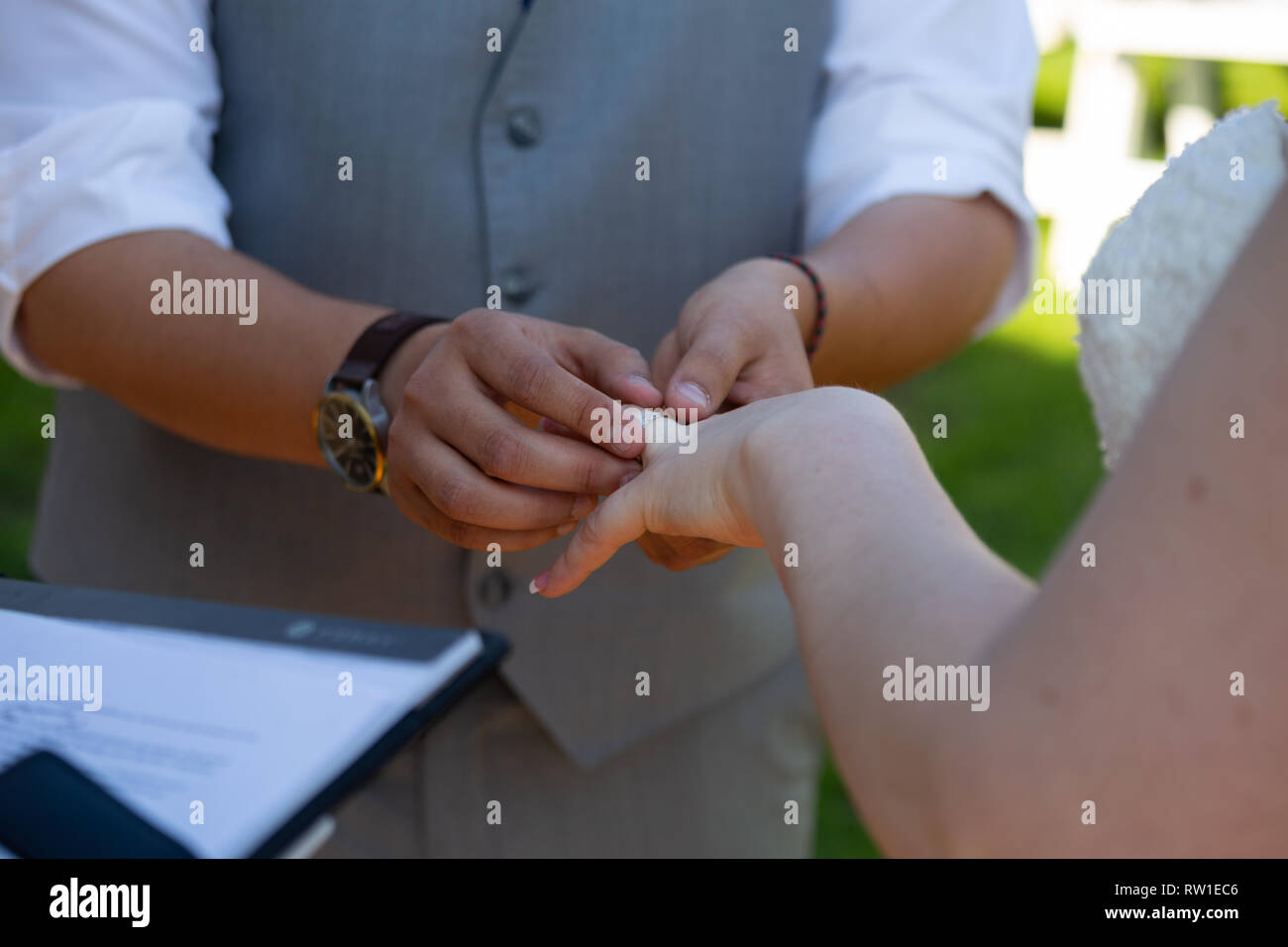 Lo sposo di mettere l'anello nuziale sul dito della sposa durante la cerimonia di matrimonio Foto Stock