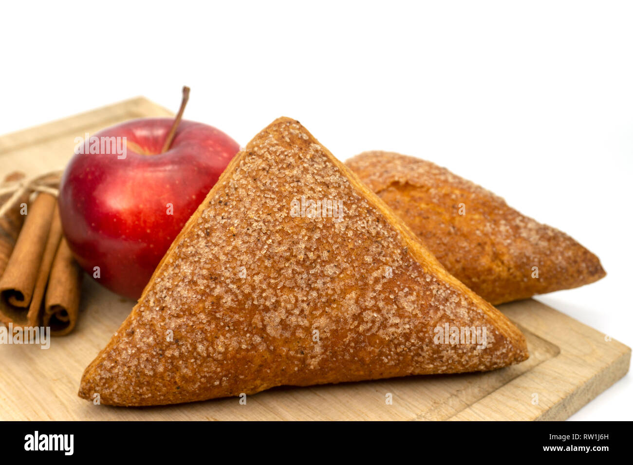 In casa di pasta sfoglia fatturati Apple, Apple e bastoncini di cannella su un tagliere di legno isolato su sfondo bianco Foto Stock