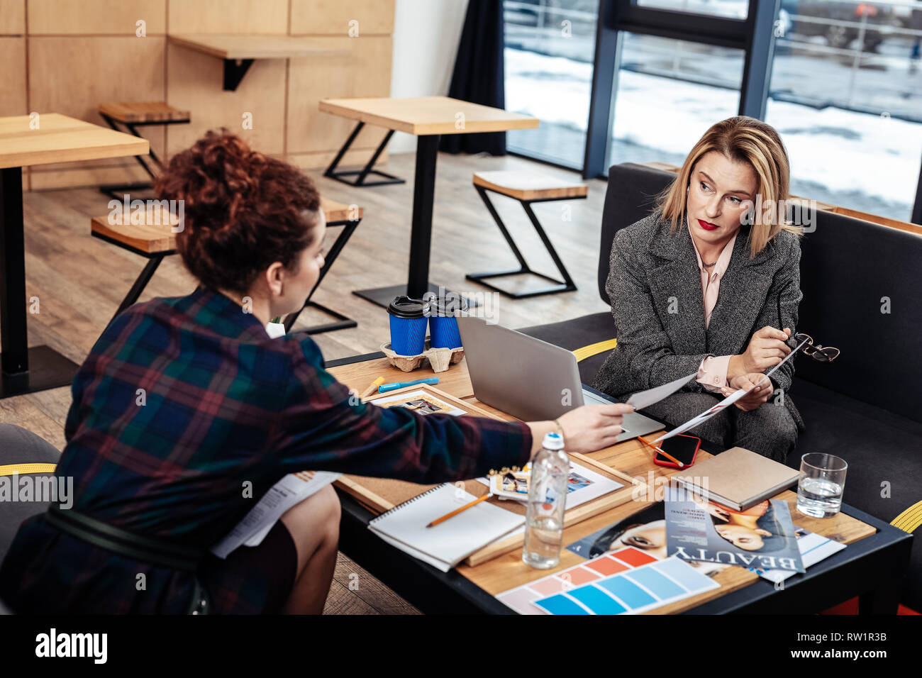 Assistente personale aiutandola occupato del duro lavoro boss femmina Foto Stock