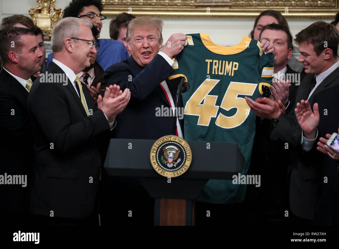 Il Presidente degli Stati Uniti, Trump riceve una maglia da calcio con il suo nome su di esso dal quarterback Easton Stick, destra, come egli saluta la divisione 2018 mi FCS campioni nazionali: dello stato del North Dakota Bison nello stato in sala da pranzo della Casa Bianca il 4 marzo 2019 a Washington, DC. Credito: Oliver Contreras / Pool via CNP /MediaPunch Foto Stock