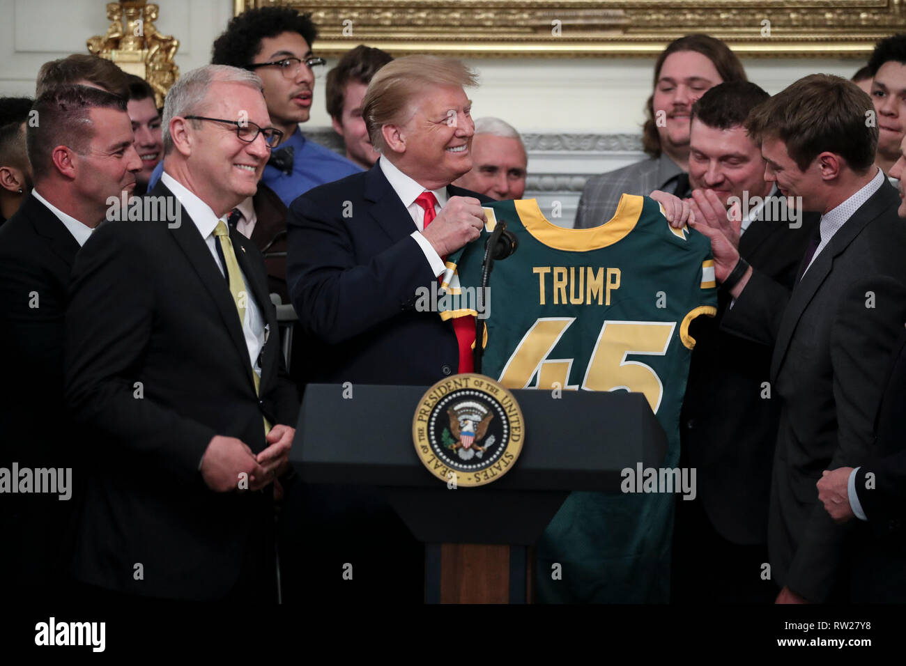 Il Presidente degli Stati Uniti, Trump riceve una maglia da calcio con il suo nome su di esso dal quarterback Easton Stick, destra, come egli saluta la divisione 2018 mi FCS campioni nazionali: dello stato del North Dakota Bison nello stato in sala da pranzo della Casa Bianca il 4 marzo 2019 a Washington, DC. Credito: Oliver Contreras / Pool via CNP /MediaPunch Foto Stock