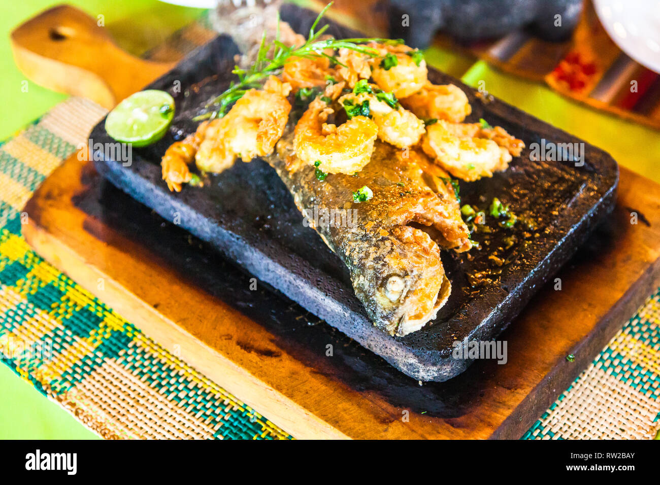 Trote sulla pietra; tutta la trota, servita sulla pietra calda con gamberetti Foto Stock