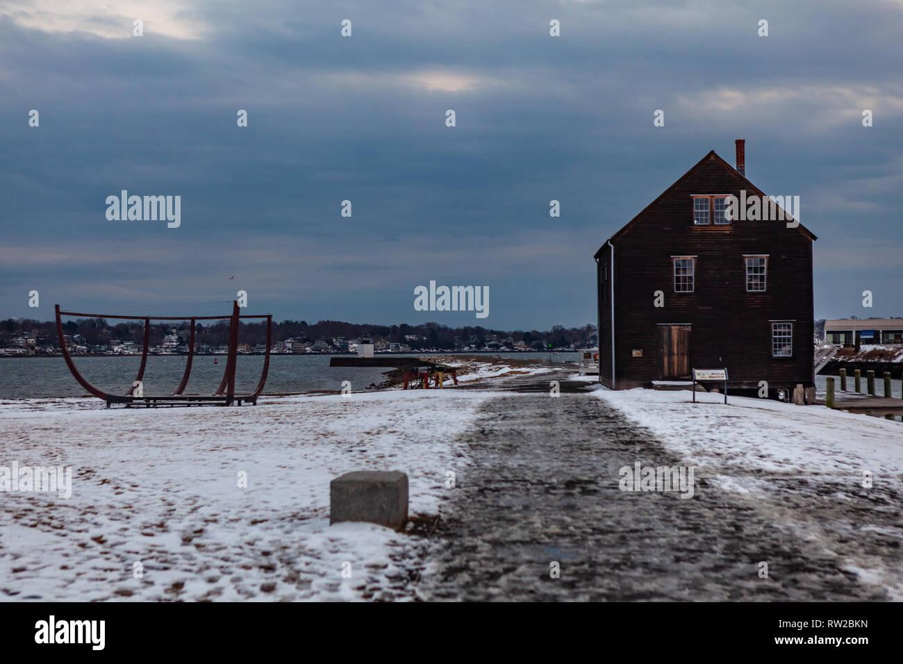 Salem, Massachusetts, STATI UNITI D'America - 14 Settembre 2016: Magico tramonto in inverno con un grande edificio marrone situato nei pressi di acque calme in Salem's historic district, Mas Foto Stock
