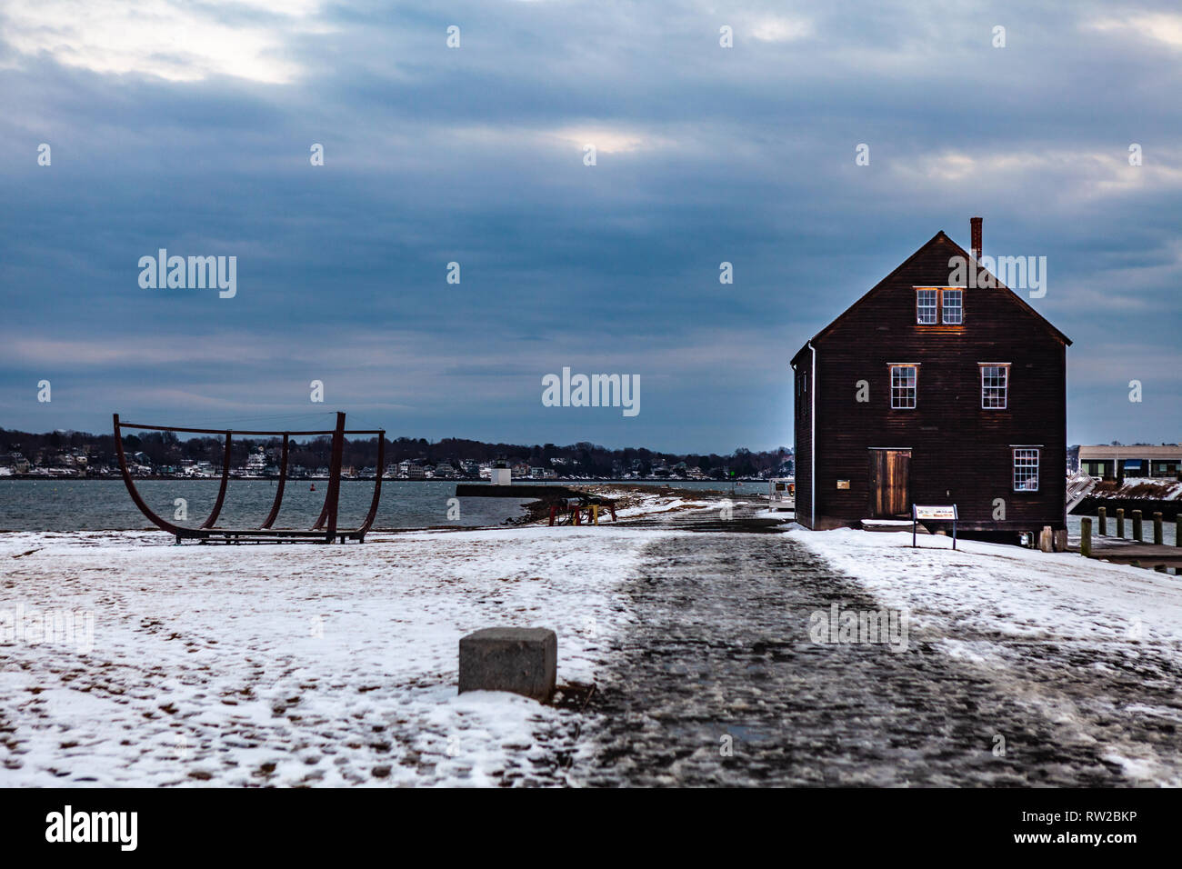 Salem, Massachusetts, STATI UNITI D'America - 14 Settembre 2016: Magico tramonto in inverno con un grande edificio marrone situato nei pressi di acque calme in Salem's historic district, Mas Foto Stock