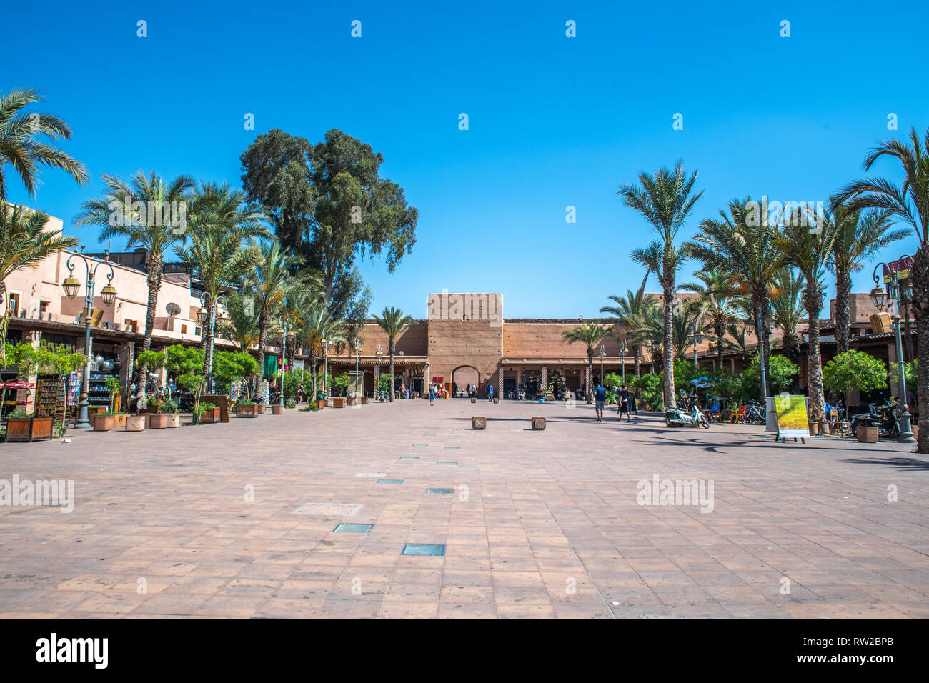 Vuoto cortile aperto costeggiata da negozi tutto intorno con il blu del cielo sopra, Marrekech, Marocco Foto Stock