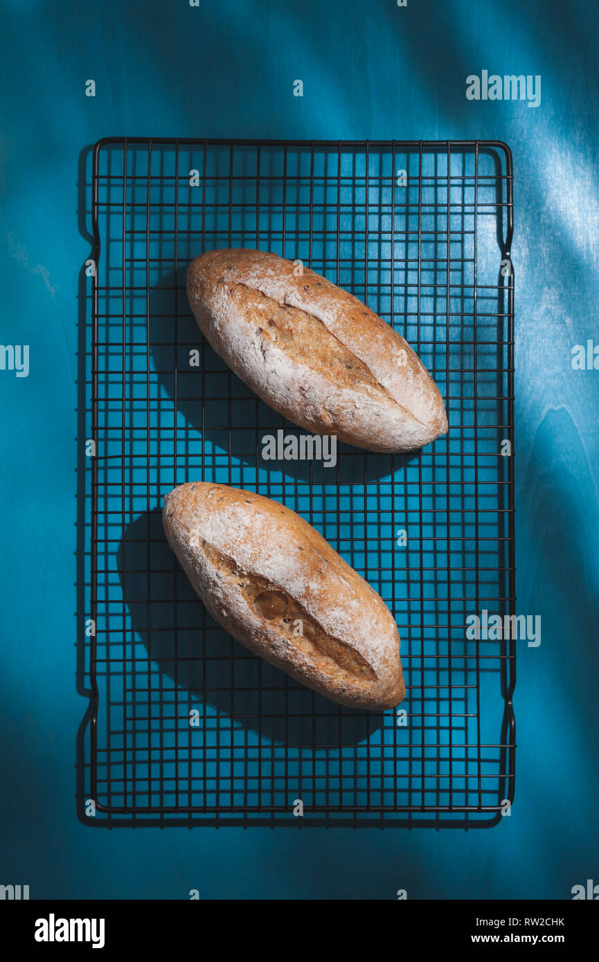 Baguette, in stile Europeo pane blu sulla tavola di legno in mattina tempo con disco effetto di luce. Organici e salutari pasto in stile minimal concept Foto Stock