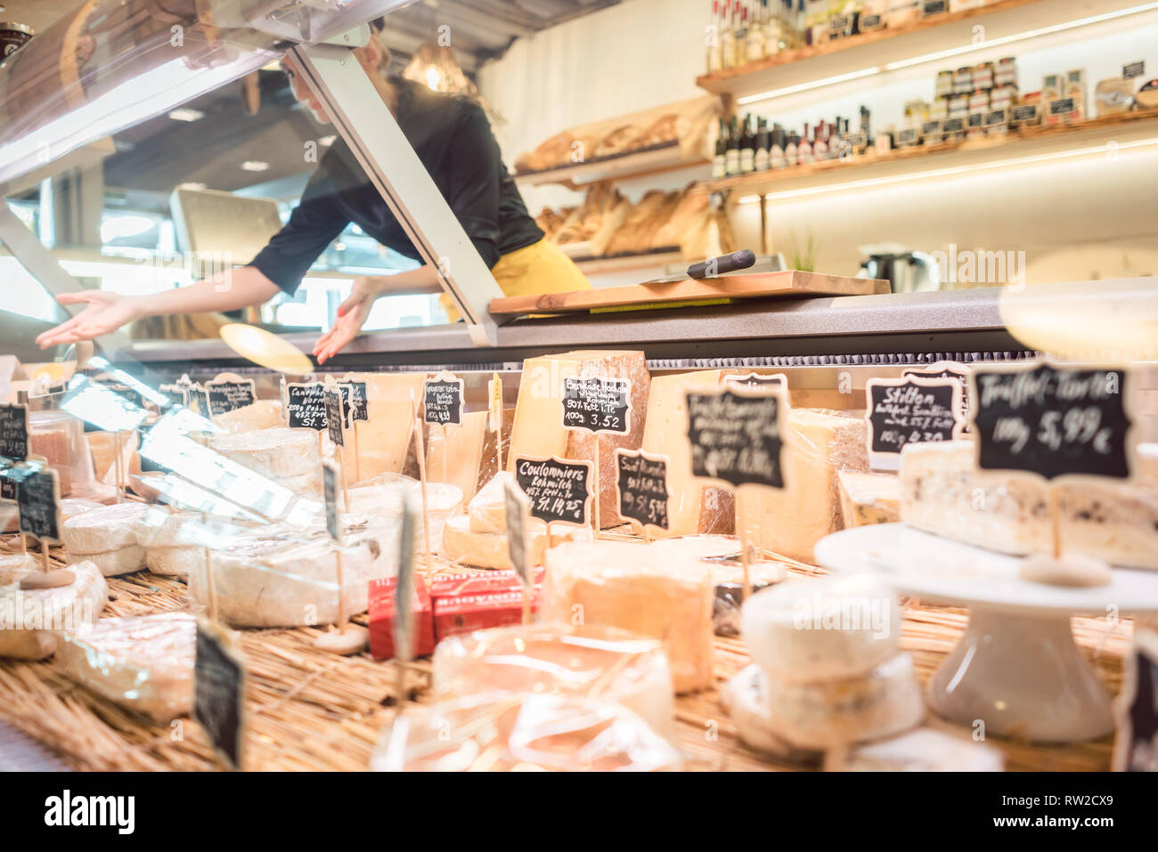 Commessa donna formaggio di smistamento nel supermercato display Foto Stock