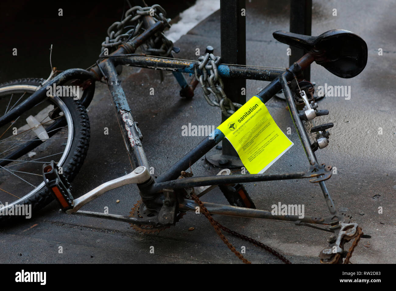 Una bicicletta con un NYC Dipartimento di Igiene bicicletta abbandonati avviso attaccato Foto Stock
