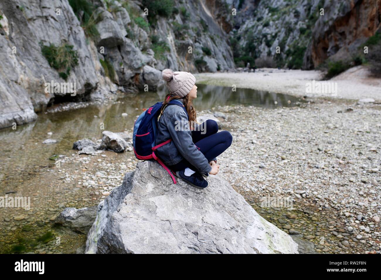 Bambino da solo escursionismo seduto vicino a un lago di montagna in appoggio sulla pista Foto Stock