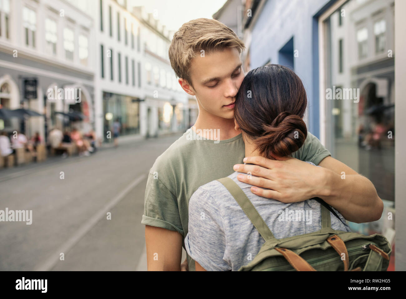 Giovane uomo di baciare la sua ragazza su una strada di città Foto Stock