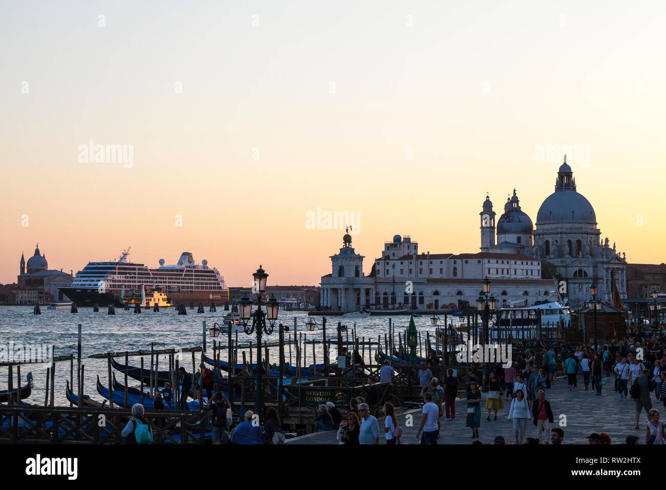 Nave da crociera Azamara Ricerca lascia Venezia al tramonto passando la Basilica di Santa Maria della Salute e Punta della Dogana da Riva degli Schiavoni con Foto Stock
