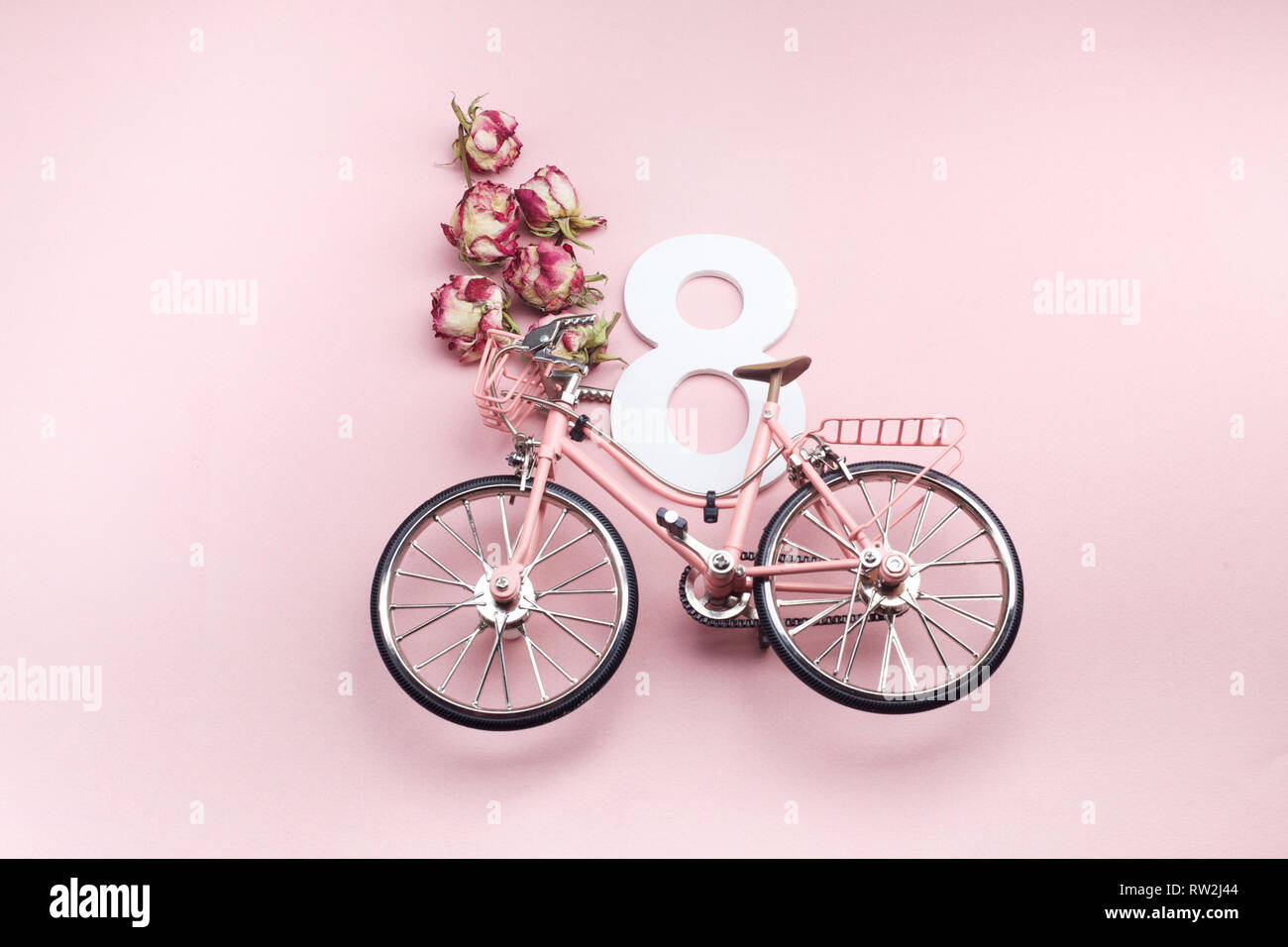 Felice International Womens Day Celebriamo a otto marzo. Numero otto con bicicletta rosa su sfondo rosa Foto Stock