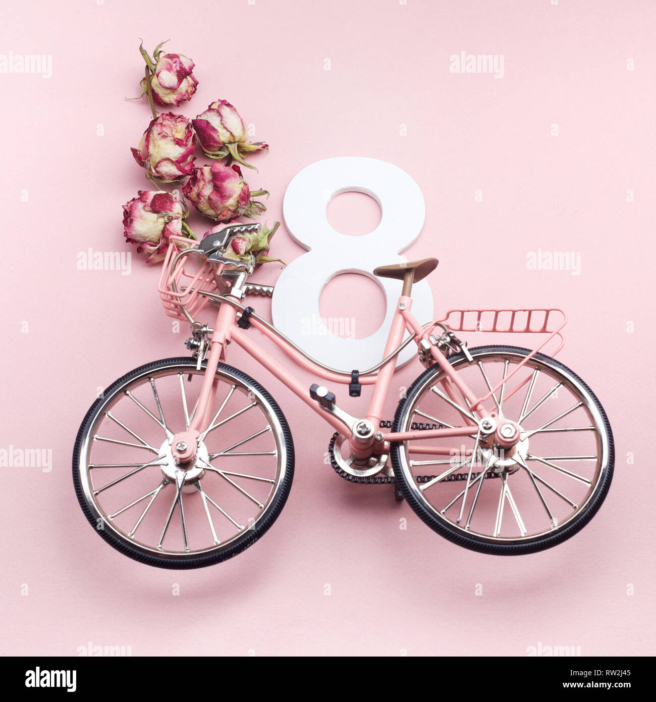 Felice International Womens Day Celebriamo a otto marzo. Numero otto con bicicletta rosa su sfondo rosa Foto Stock