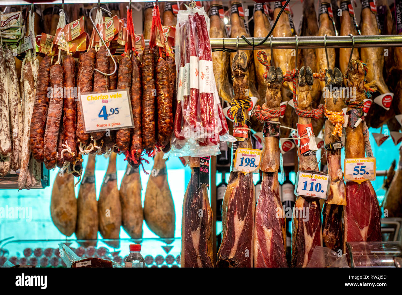 Salsiccia secca e prosciutto appendere in vendita presso La Boqueria Mercato alimentare di Barcellona , Spagna Foto Stock