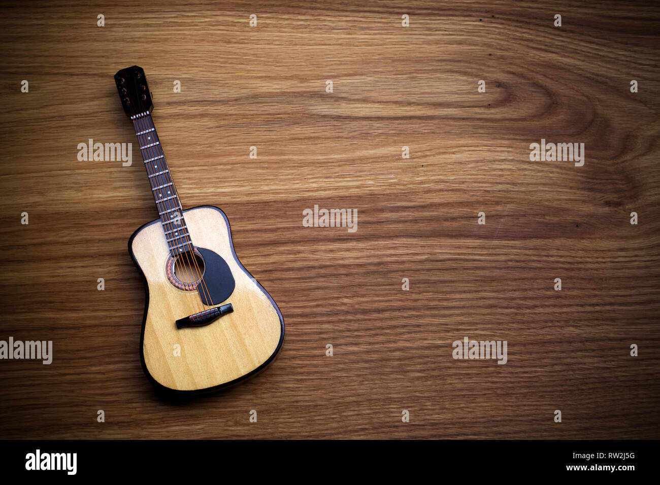Chitarra acustica contro un vecchio sfondo di legno. Foto Stock