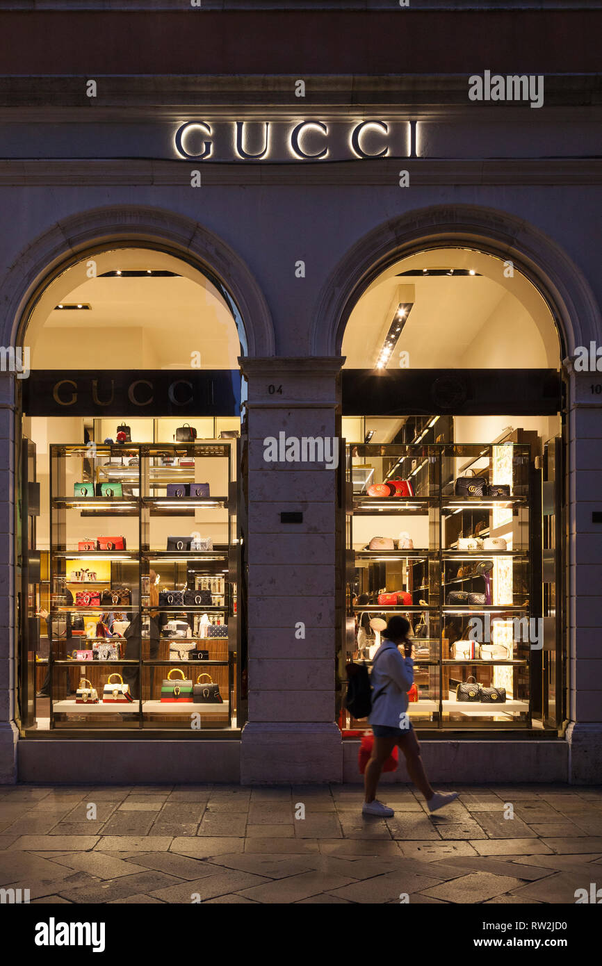 Gucci retail outlet in Calle Larga XXII Marzo, San Marco, Venezia, Veneto,  Italia illuminata di notte con segnaletica e una donna passato a piedi Foto  stock - Alamy