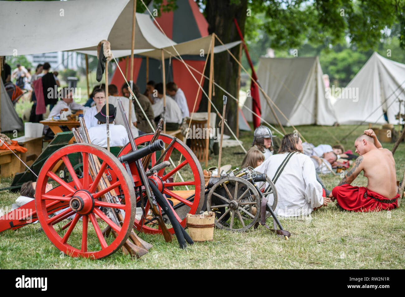 I frequentatori del festival sedersi e rilassarsi sul terreno e sotto le tende con armi medioevali sparsi attorno all annuale di St John's Fair - Świętojański Jarmark - , Foto Stock