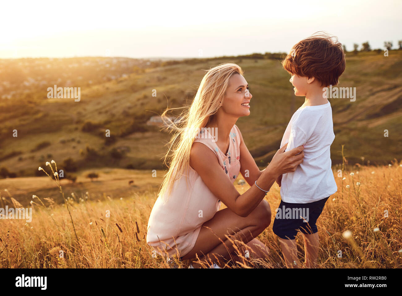 Una madre bacia il figlio nella natura. Foto Stock