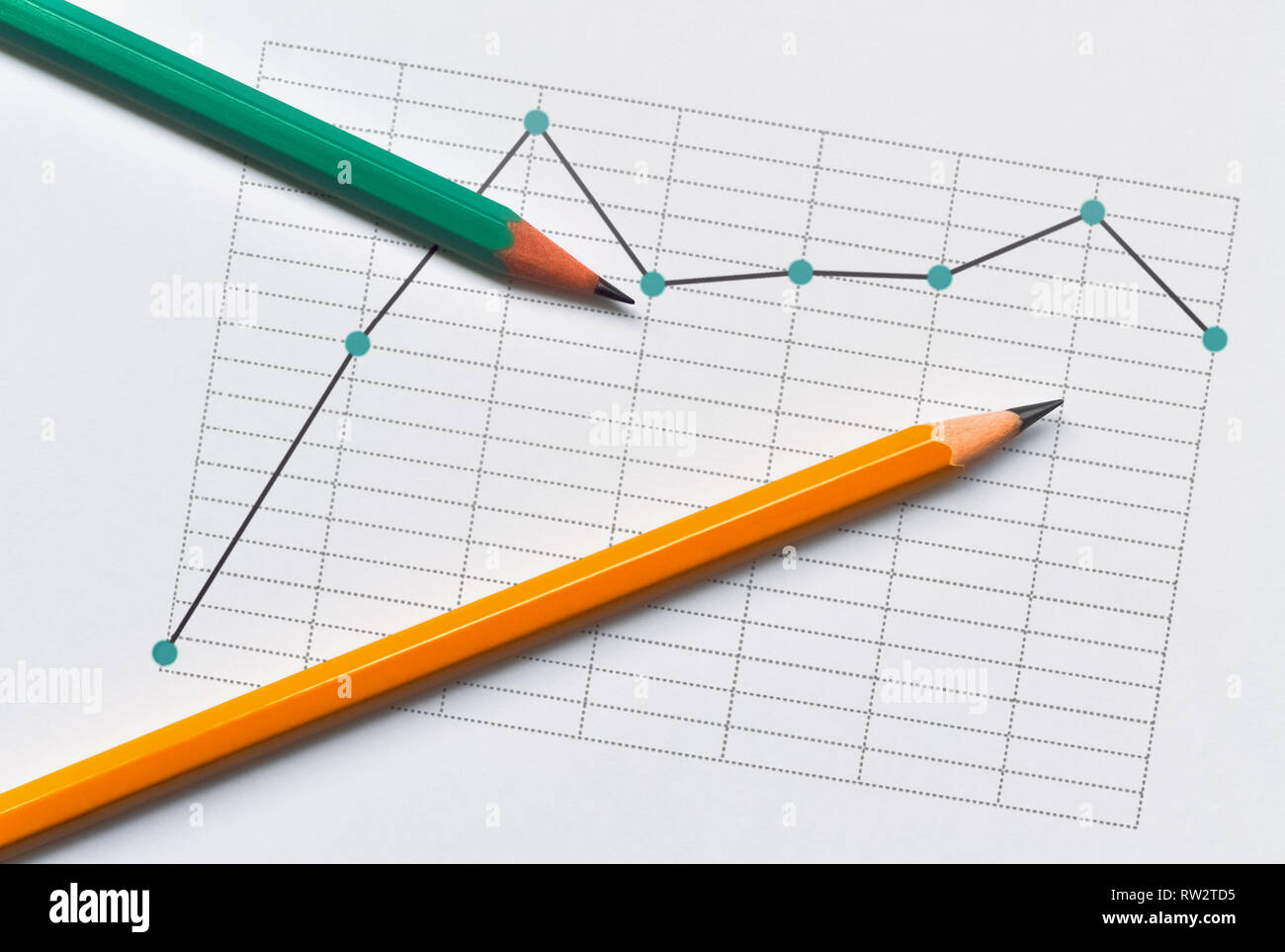La linea tratteggiata il grafico che rappresenta i dati e due matite su sfondo lucido Foto Stock