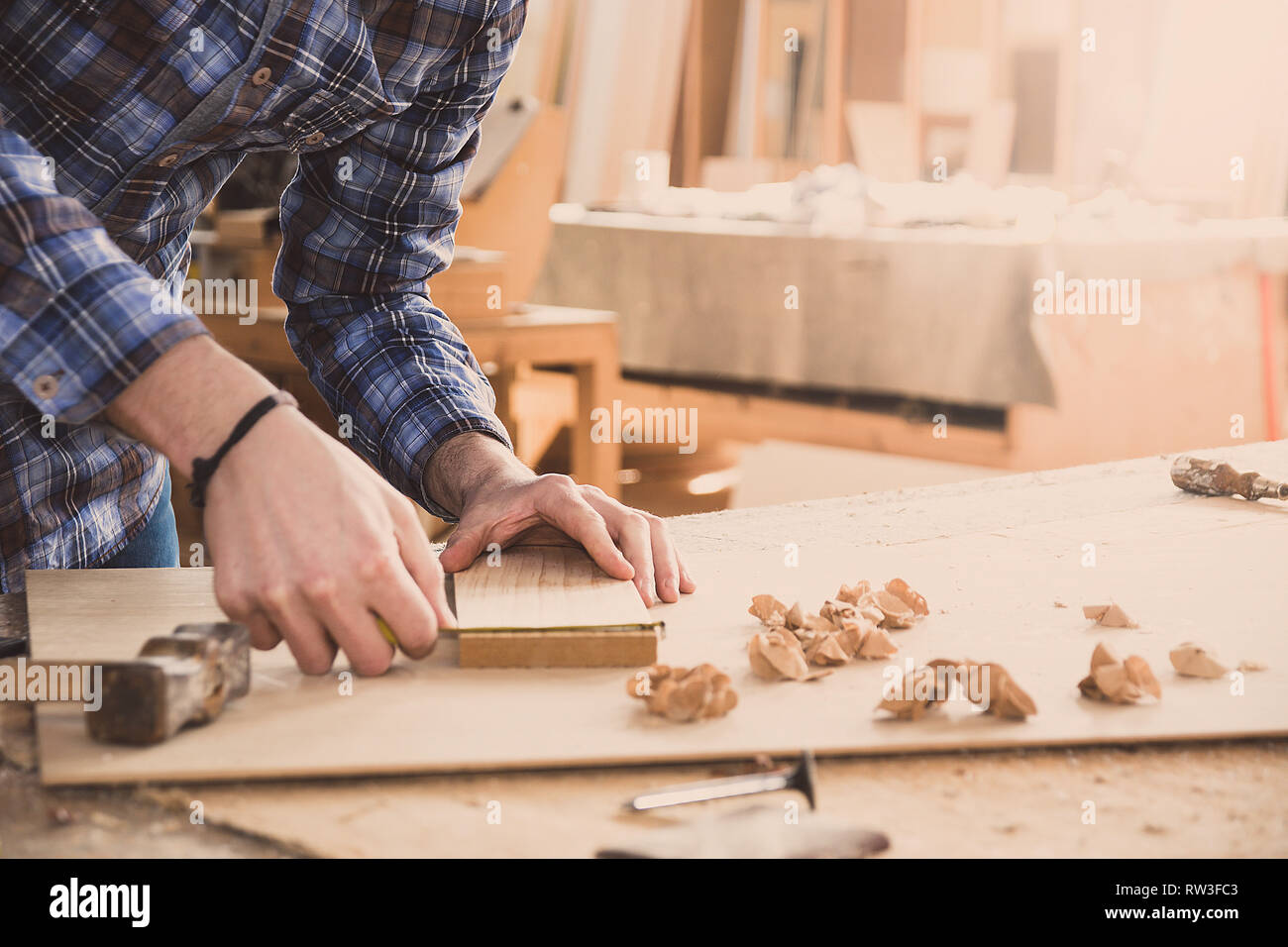 Carpenter tenendo un metro a nastro sul tavolo. Il lavoro di falegnameria officina da banco Foto Stock