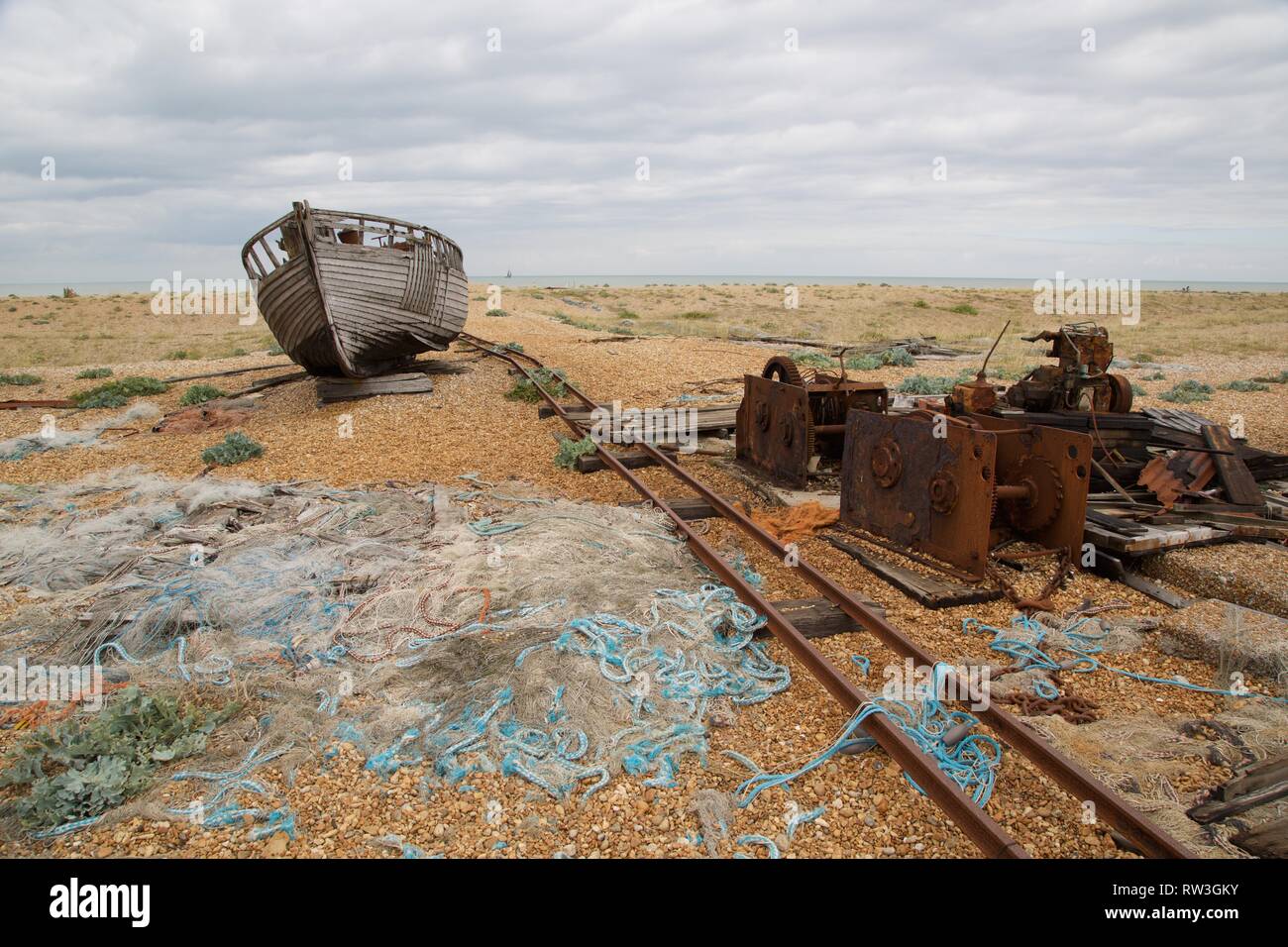 Naufraghi in barca sulla sabbia di Dungeness Kent, tetro paesaggio Foto Stock