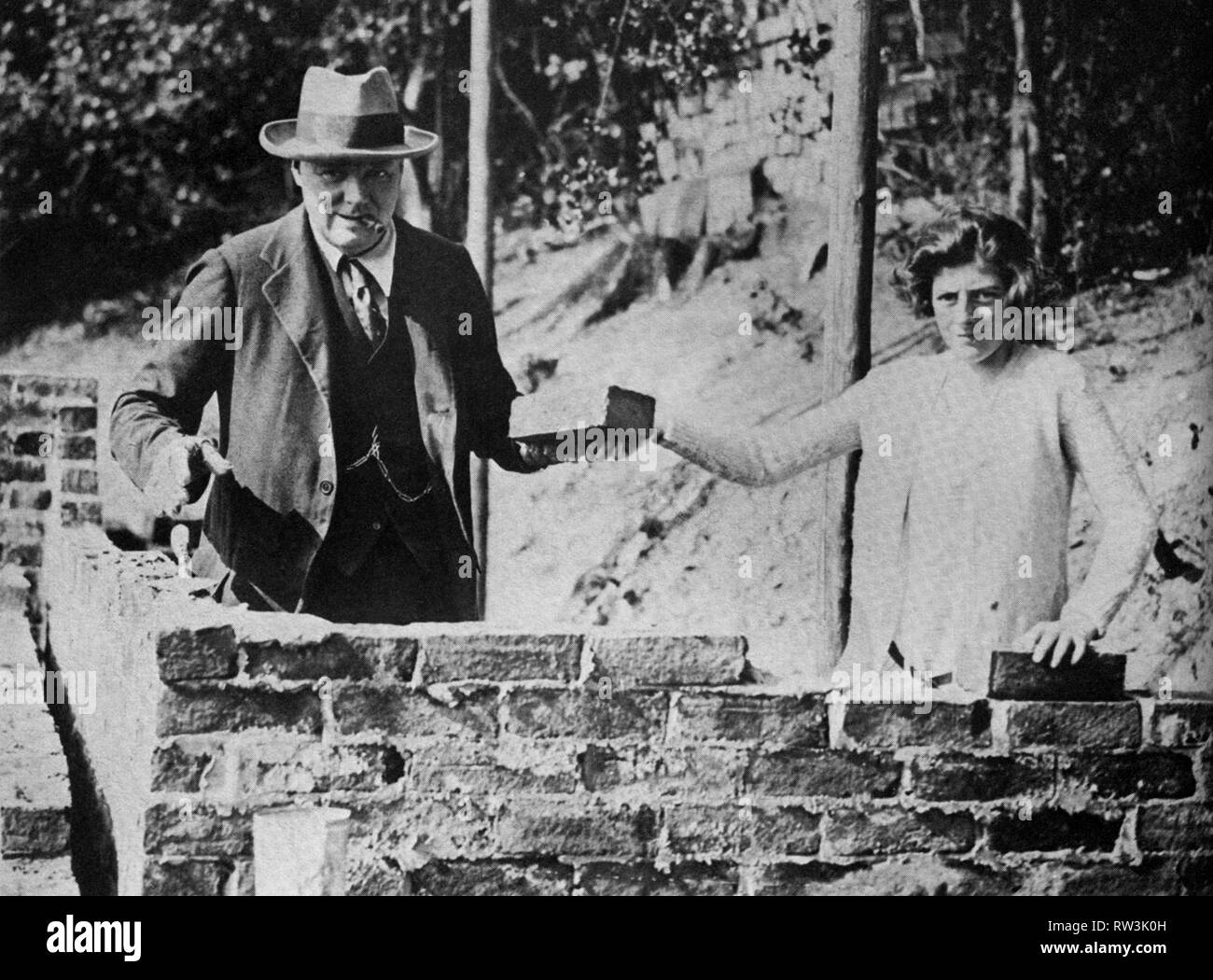 Winston Churchill con sua figlia, Sarah, che stende mattoni a Chartwell. Settembre 1928. Foto Stock