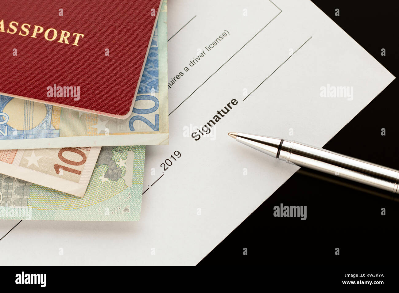 Firma, la firma di un documento. Passaporto con banconote in euro. Argomenti di autonoleggio, car sharing, indennità di assicurazione Foto Stock