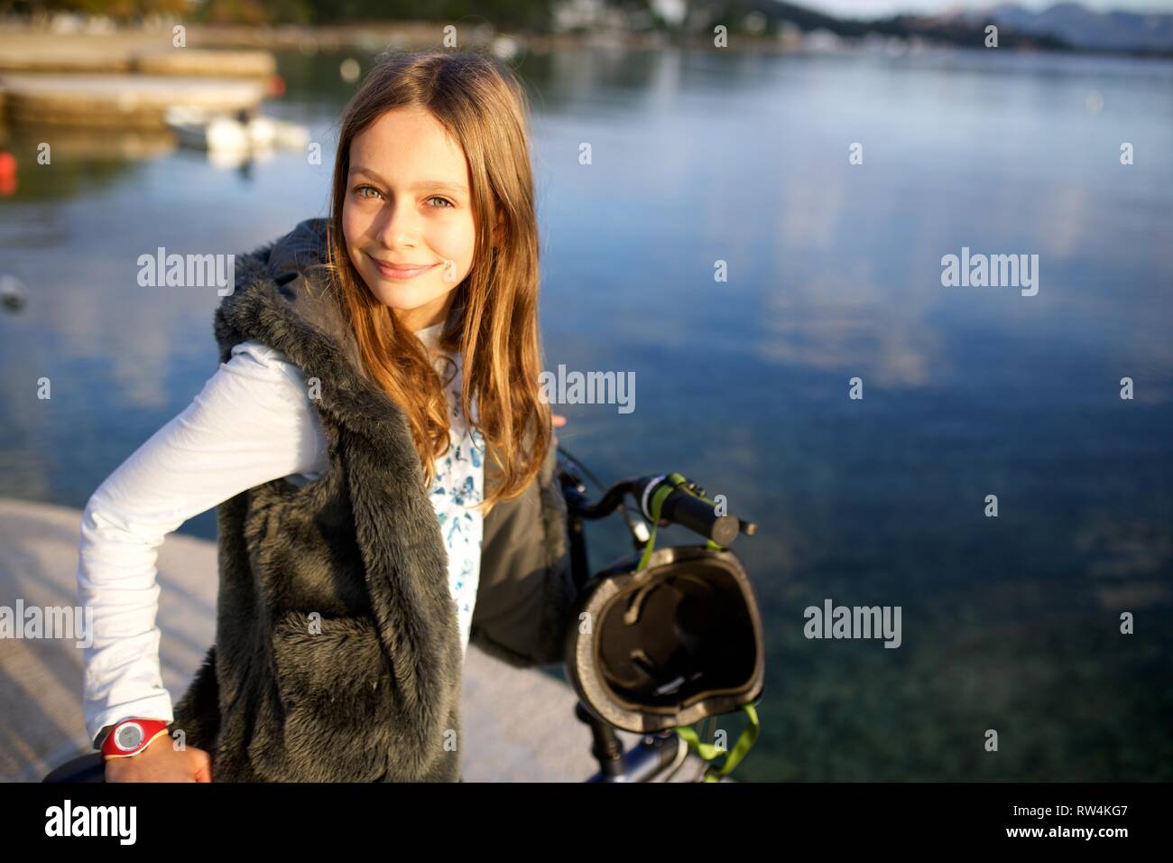 Pretty Girl Escursioni in bicicletta sulla spiaggia in una giornata di sole Foto Stock