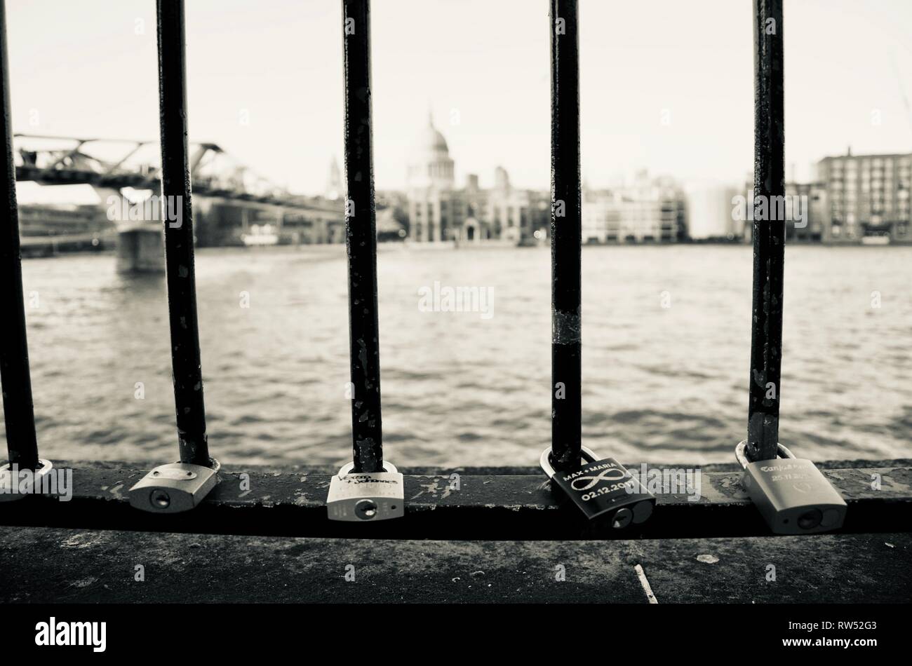 Amore si blocca o amore lucchetti sulle ringhiere sul terrapieno sul fiume Tamigi di fronte la Cattedrale di St Paul, Londra, Regno Unito. Tono di selenio. Monocromatico. Foto Stock