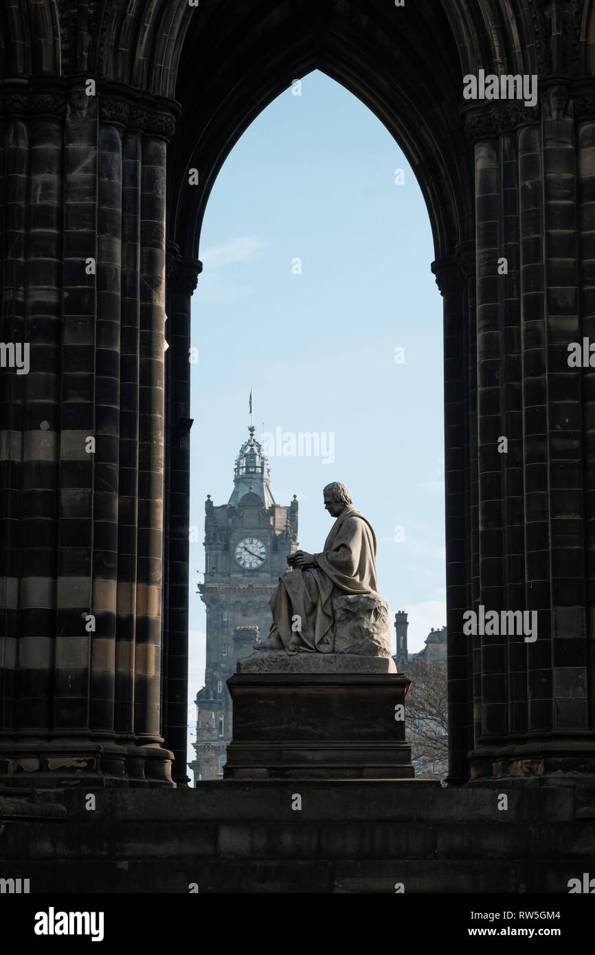 Vista attraverso il Monumento di Scott verso la torre dell orologio in background in una giornata di sole, Edimburgo, Scozia Foto Stock