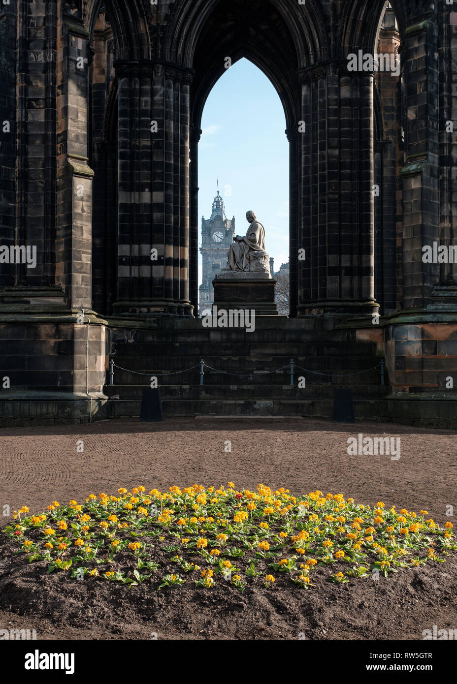 Vista attraverso il Monumento di Scott verso la torre dell orologio in background in una giornata di sole, Edimburgo, Scozia Foto Stock