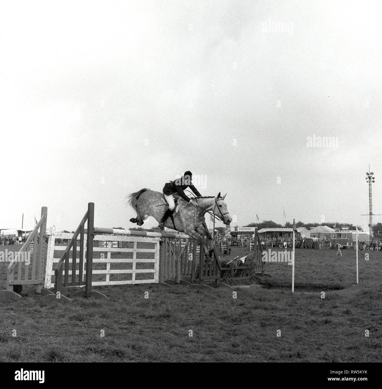 1967, ragazza adolescente rider su un cavallo che salta da un recinto o ostacolo alla contea di Bucks mostrano, Engand, UK. Foto Stock