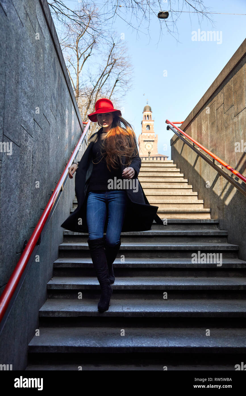 La ragazza con il cappello rosso e un mantello nero scende e entra nel  Cairoli la Stazione della Metropolitana di Milano Italia Foto stock - Alamy