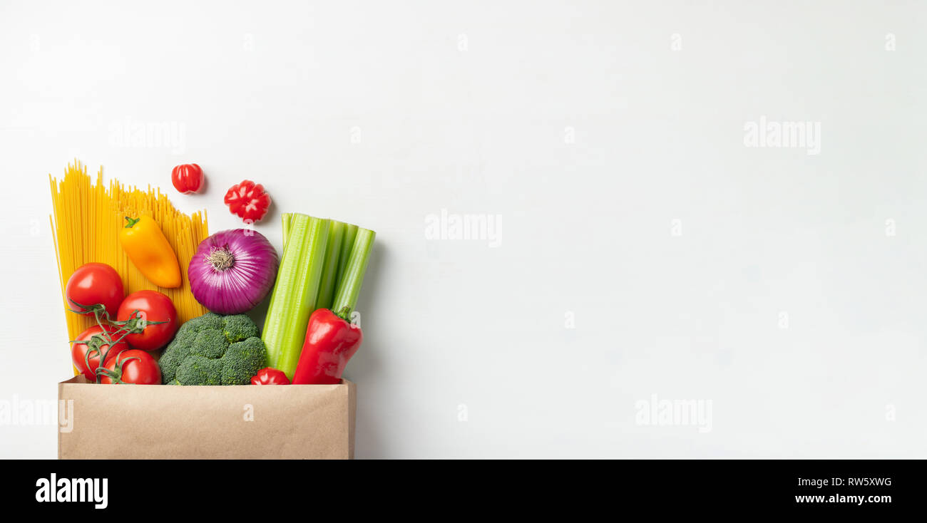 Sacchetto di carta di diversi alimenti sani su uno sfondo bianco. Vista dall'alto. Lay piatto. Copia dello spazio. Foto Stock