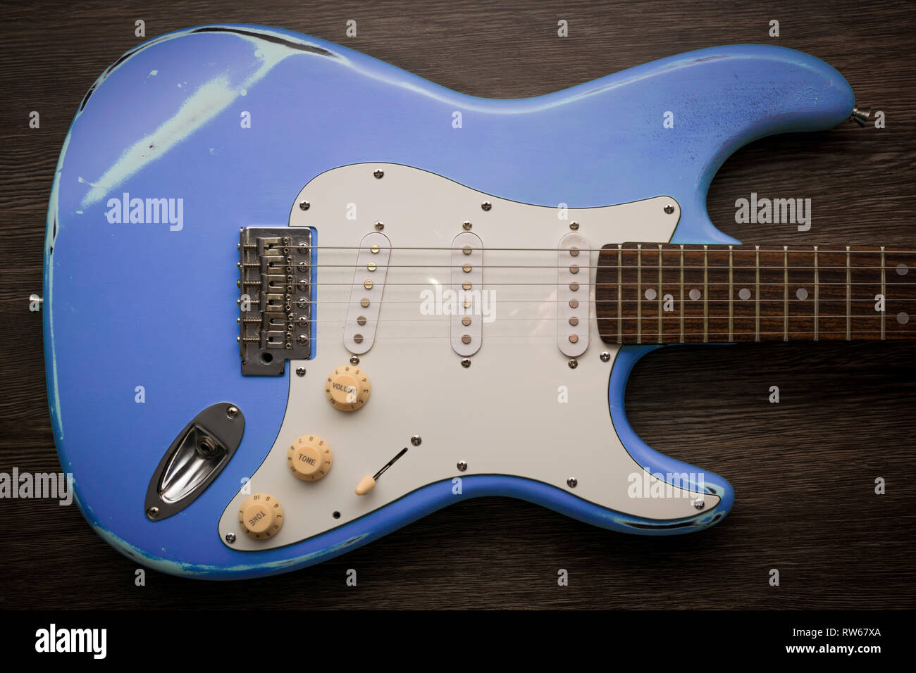 Blue chitarra elettrica marrone contro uno sfondo di legno. Età Vintage  indossato la chitarra. Chitarra Techno Foto stock - Alamy