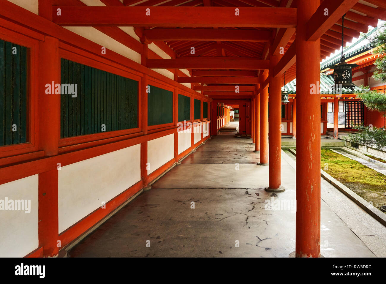Un corridoio di Vermiglio e verde a Jingu Heian (Santuario Heian) a Kyoto, in Giappone. Foto Stock