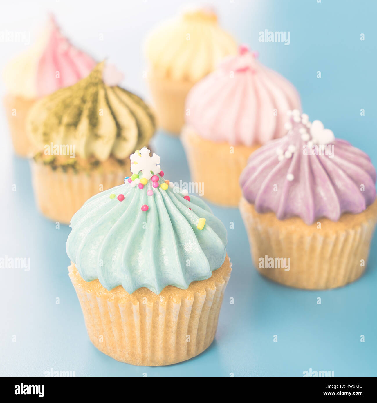 Mini Tortine di fantasia muffin luminoso su sfondo blu Foto Stock