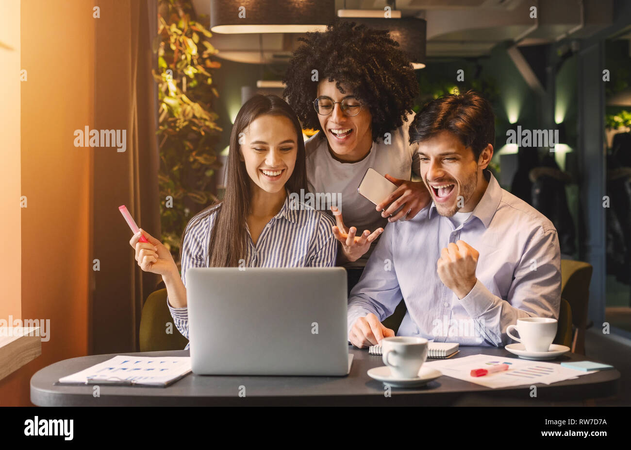 Il successo del team aziendale guardando felicemente laptop Foto Stock