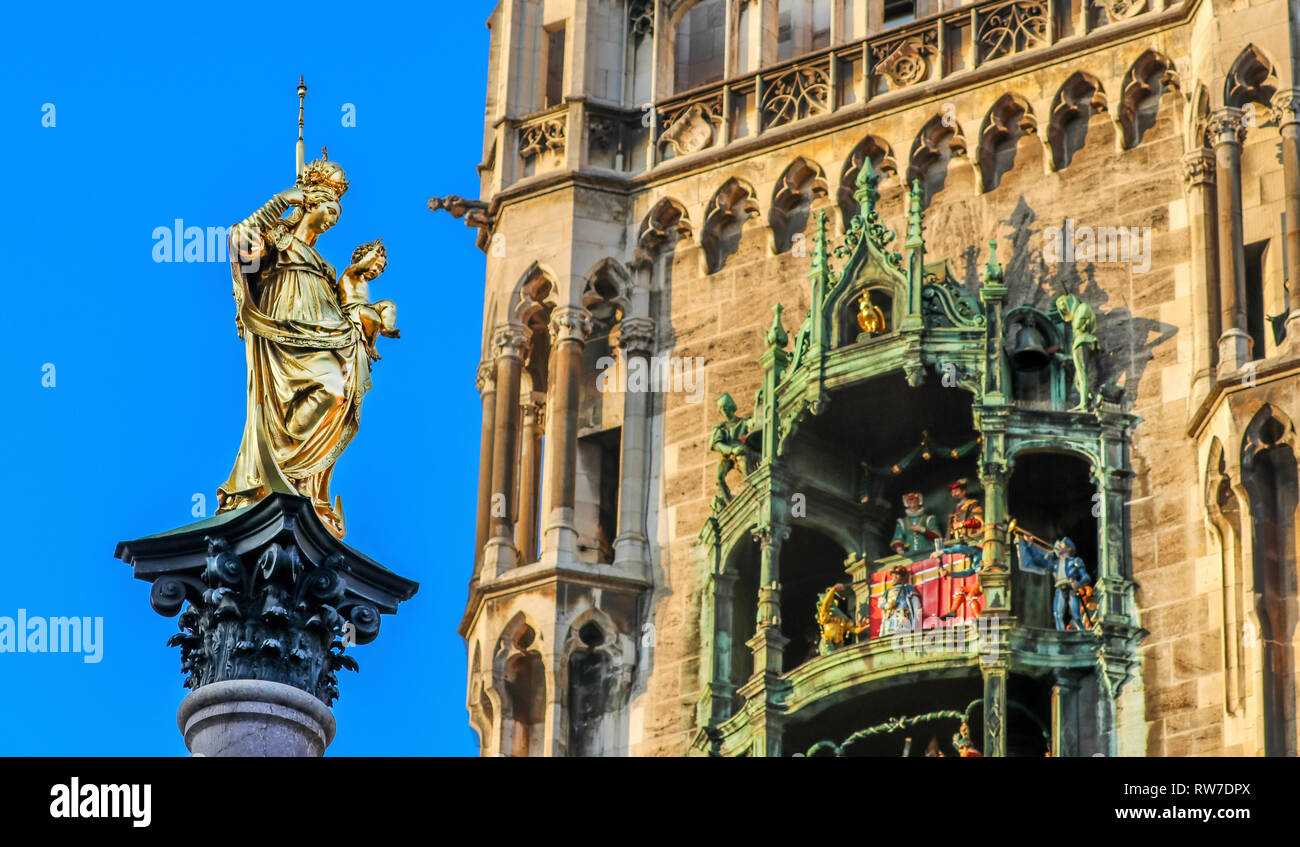 Statua dorata Mariensäule a Monaco di Baviera, Marienplatz con il famoso Glockenspiel in retro Foto Stock