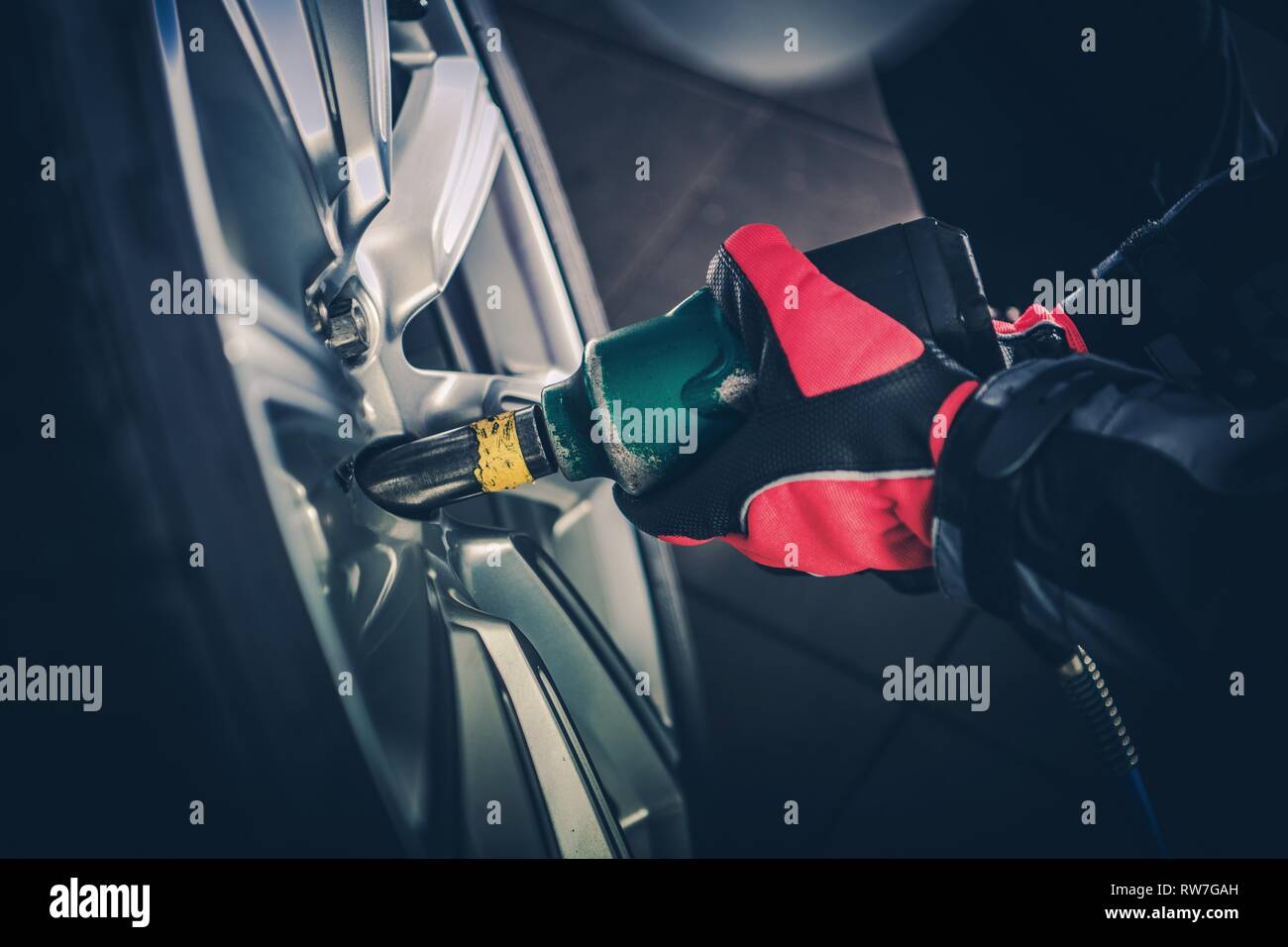 Cerchi auto manutenzione. Auto Service lavoratore con pistola pneumatica attrezzo installazione nuova ruota di veicolo. Foto Stock