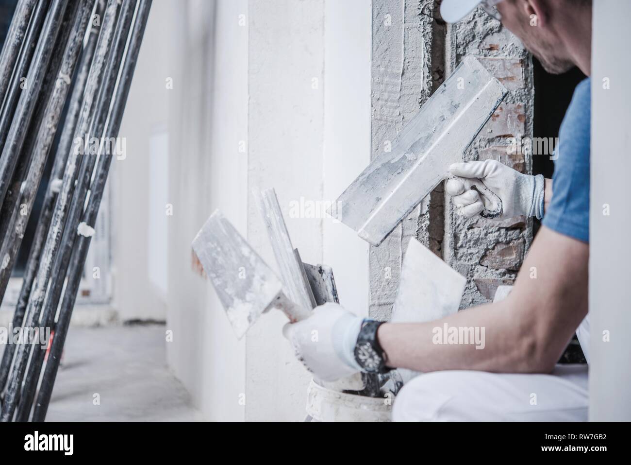 Caucasica lavoratore in muratura con mattoni e la finitura di cazzuole nelle sue mani. Industria di costruzione del tema. Foto Stock
