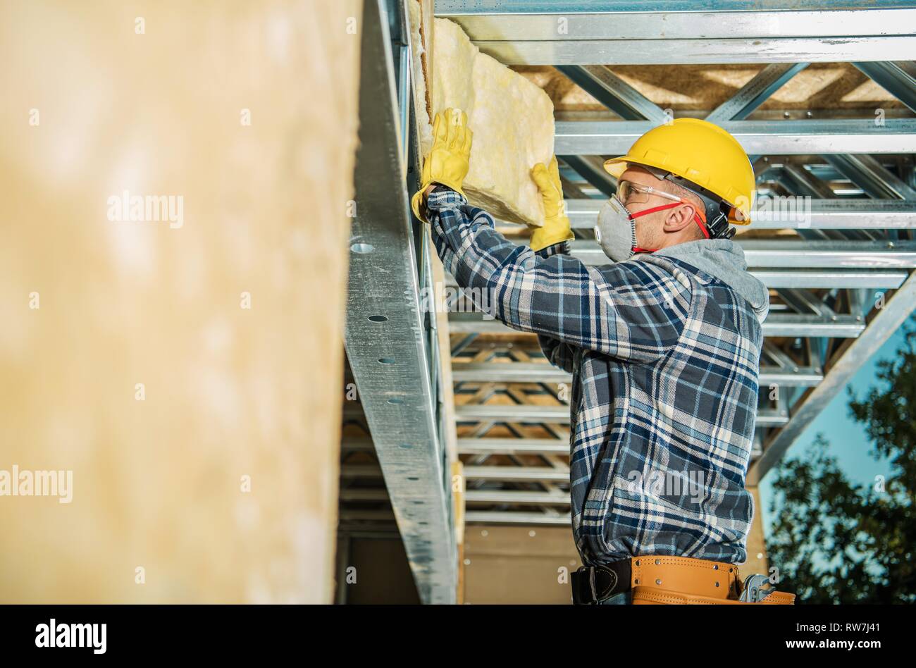 Parete di isolamento mediante installazione costruzione professionale Lavoratore. La lana minerale isolante della casa. Foto Stock