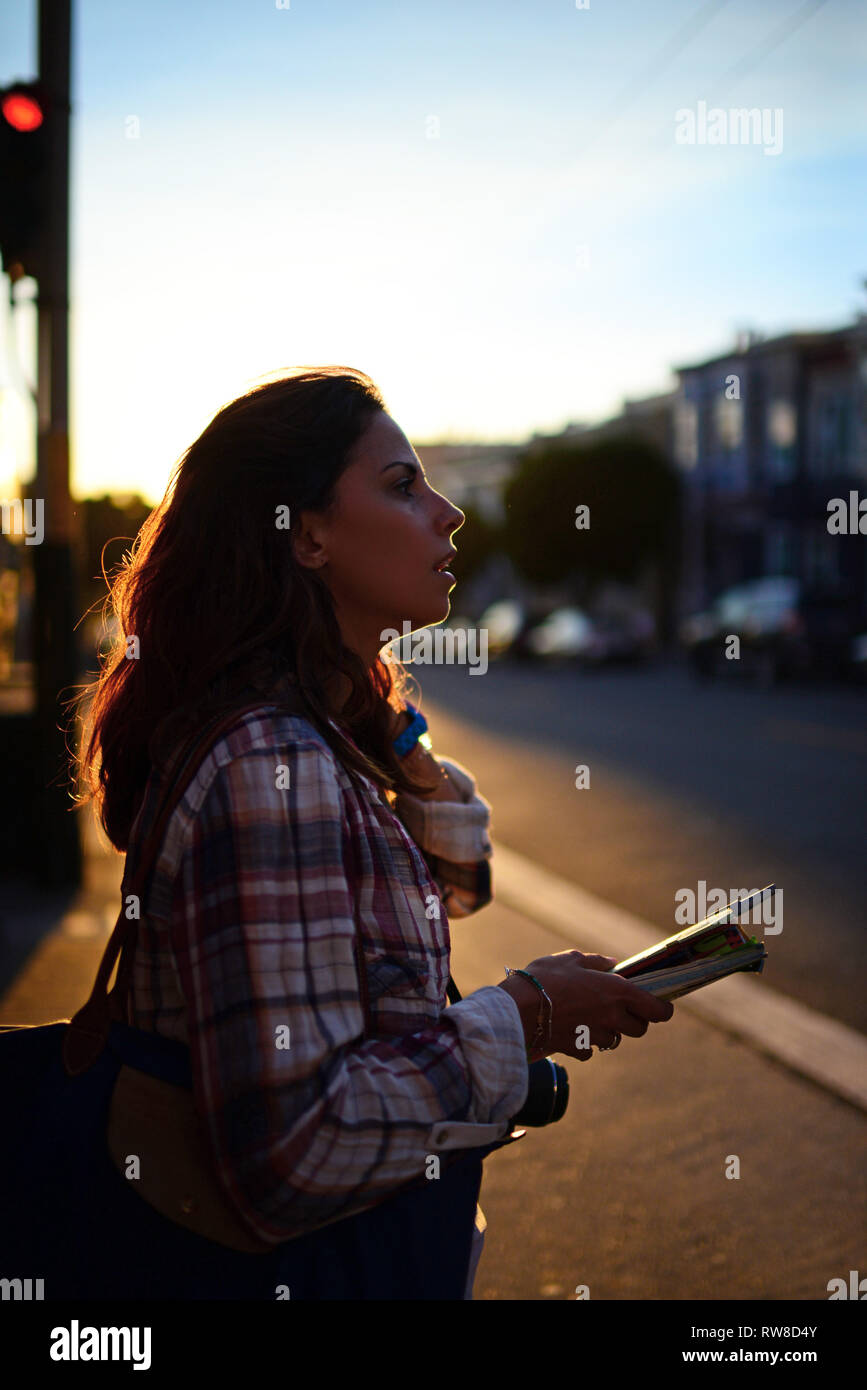 Giovane donna per le strade di San Francisco al tramonto. Foto Stock