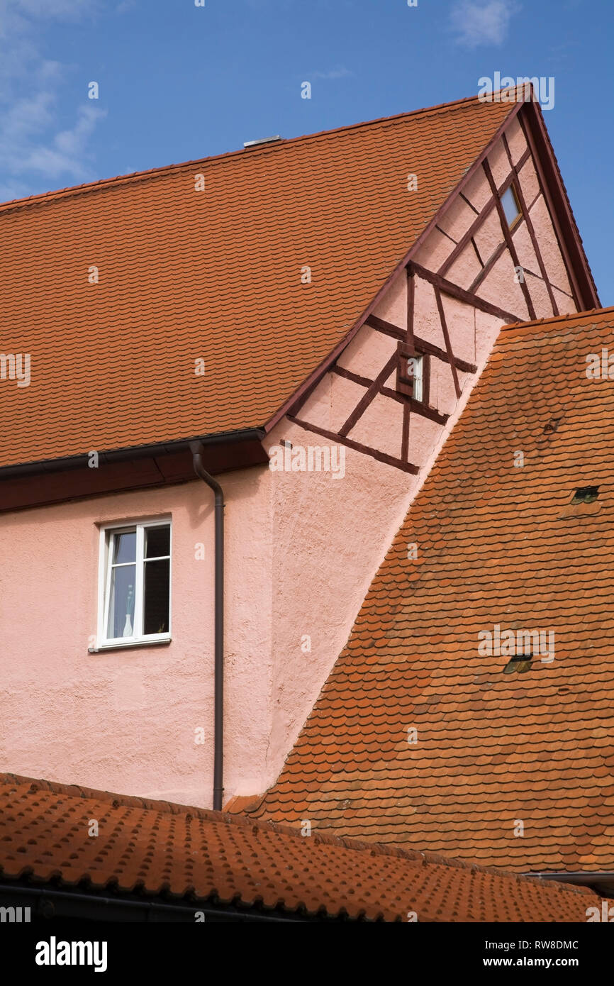 Stucco rosa casa in legno e muratura esterno con terracotta ceramica tegole del tetto nella città medievale di Nordlingen, Baviera, Germania Foto Stock