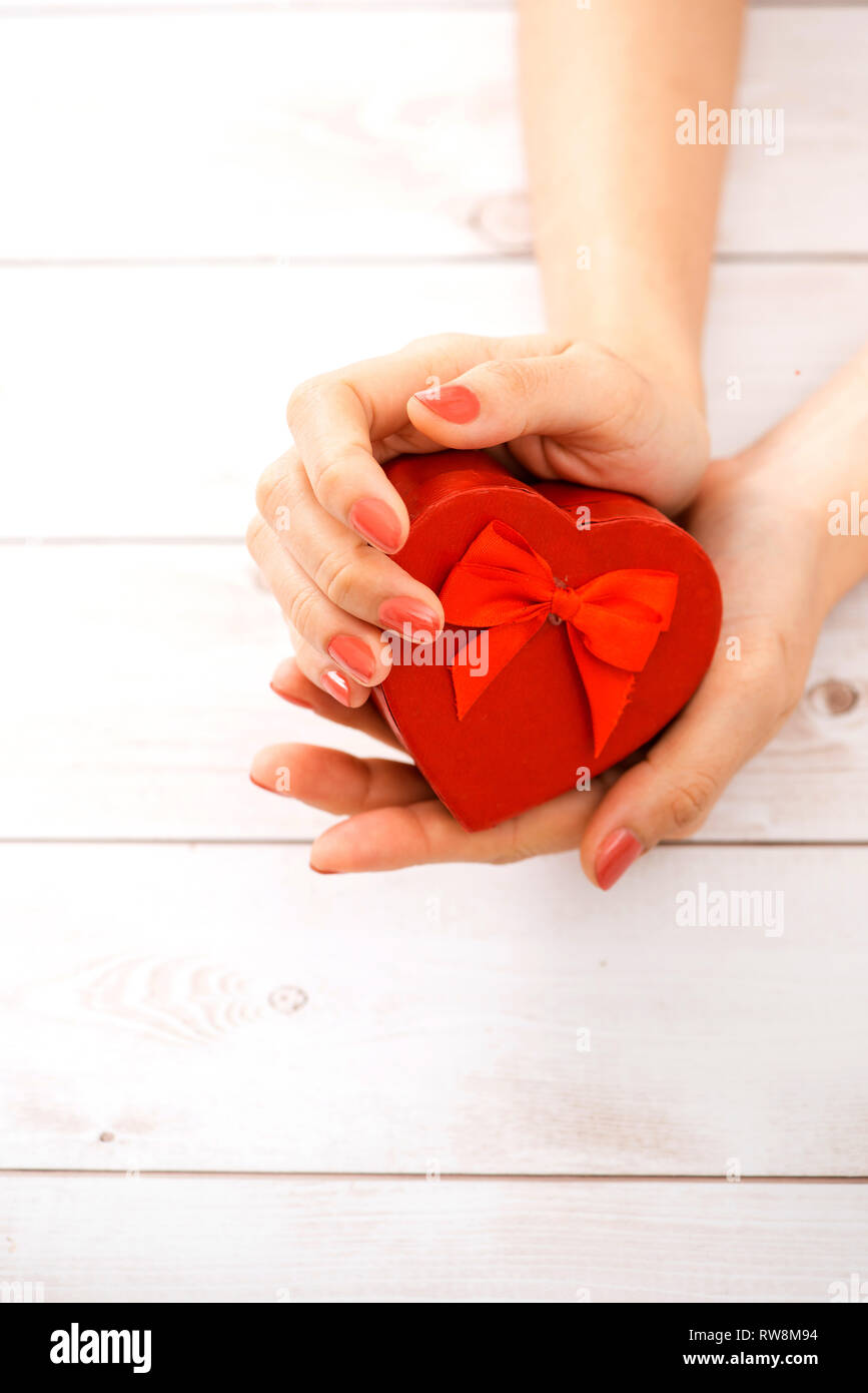 Femmina dando a mano azienda heart-shaped box Foto Stock