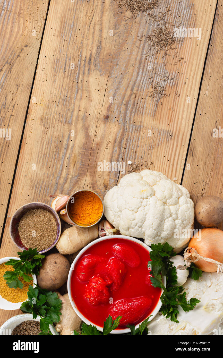 Cavolfiore al curry di materie prime per la cottura su sfondo di legno vista superiore Foto Stock