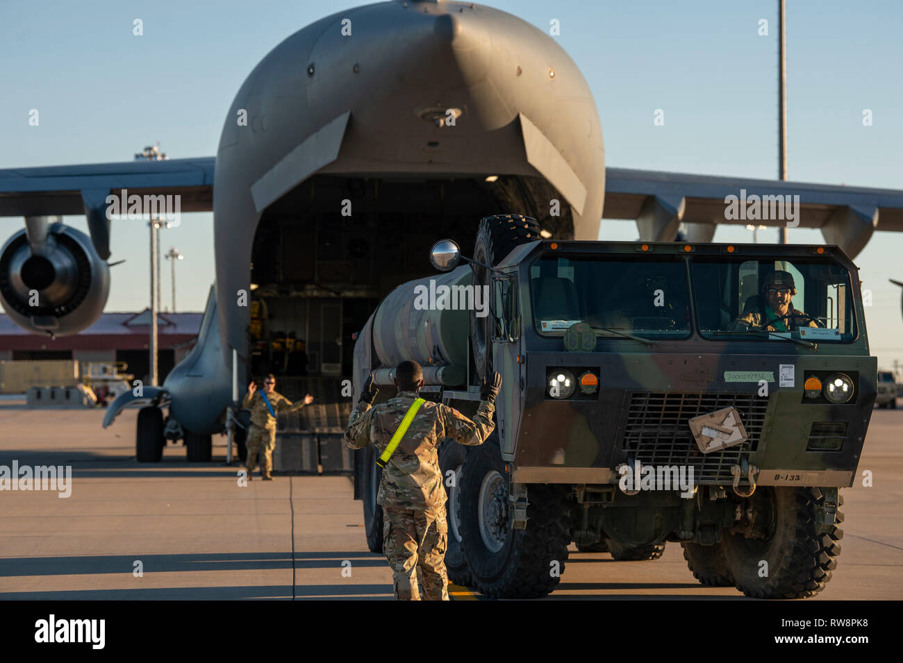 Stati Uniti I soldati dell esercito e U.S. Air Force aviatori preparare per il carico di un camion di carburante su una quarta Airlift Squadron C-17 Globemaster III a Fort Bliss, Texas, dal 23 febbraio, 2019. La THAAD Sistema per missile è una terra-piattaforma di base in grado di intercettare i missili balistici entrambi all'interno e subito fuori l'atmosfera. (U.S. Air Force photo by Staff Sgt. Cory D. Payne) Foto Stock