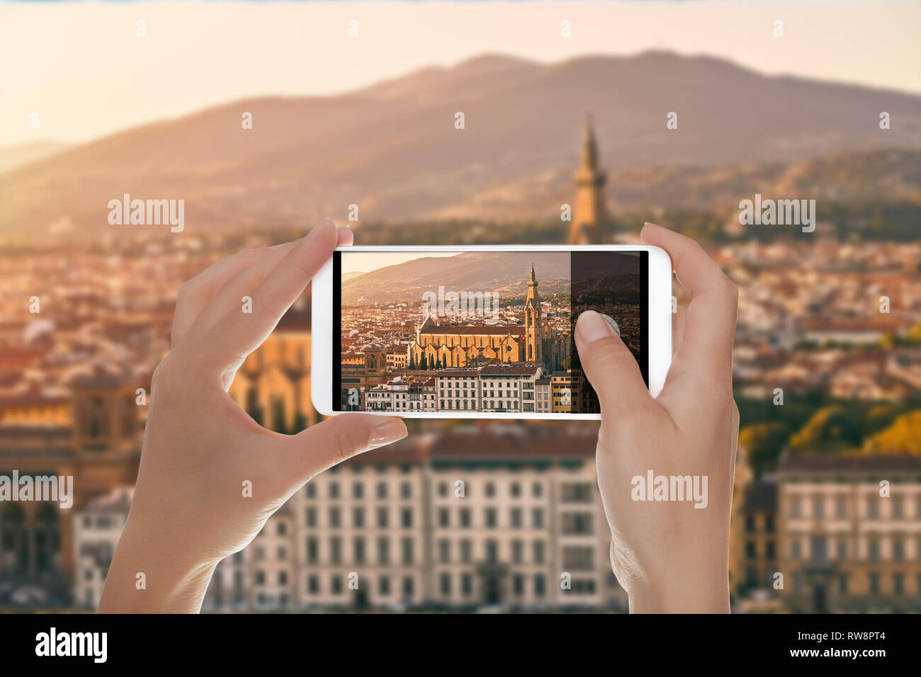 Un uomo è fare una foto del panorama di Firenze al tramonto con la Basilica di Santa Croce (Basilica di Santa Croce) illuminata dal sole di setting Foto Stock