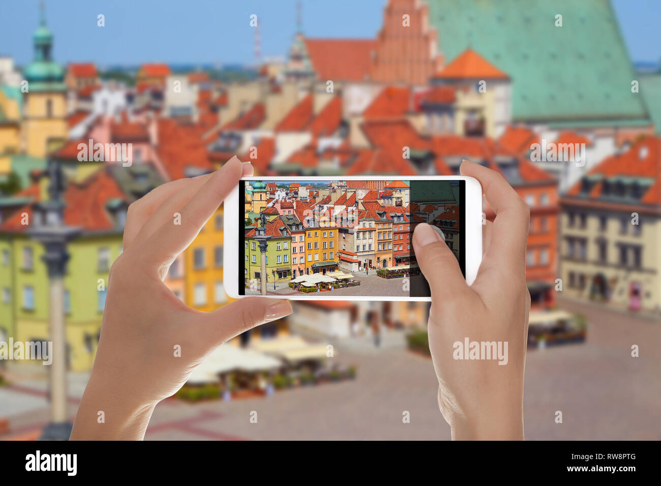 Un uomo è fare una foto della piazza principale della città vecchia a Varsavia in Polonia senza persone su un telefono cellulare Foto Stock